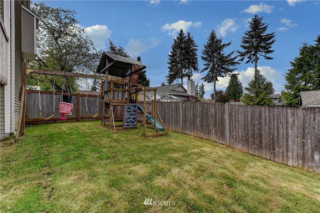 6605 Cady Road Everett, WA 98203 - Photo 25 of 26 a view of a backyard with table and chairs and wooden fence