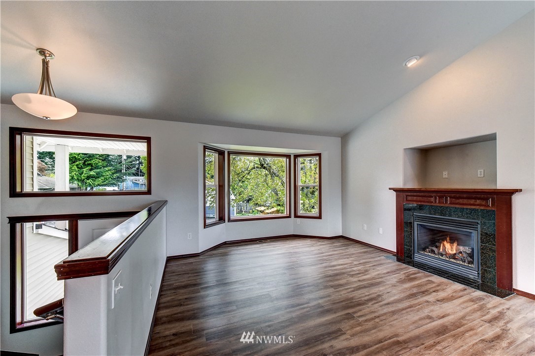 6605 Cady Road Everett, WA 98203 - Photo 5 of 26 a view of an empty room with wooden floor fireplace and a window