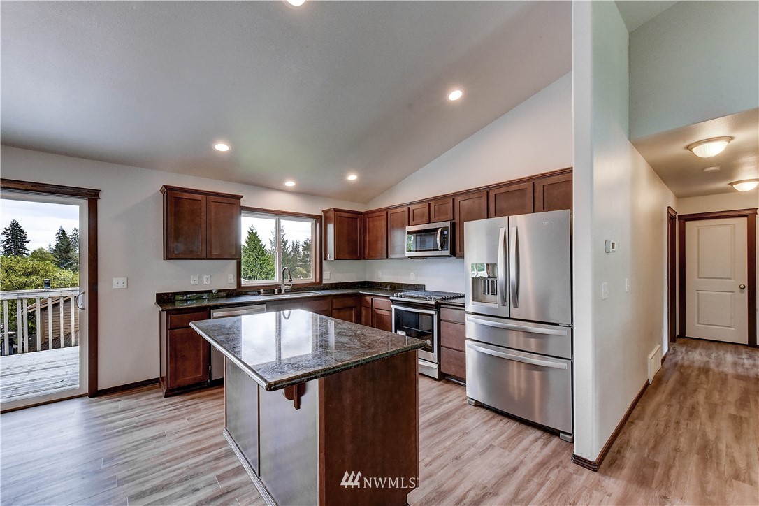 6605 Cady Road Everett, WA 98203 - Photo 6 of 26 a kitchen with stainless steel appliances wooden floor and wooden cabinets