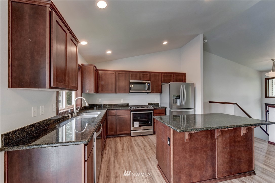 6605 Cady Road Everett, WA 98203 - Photo 10 of 26 a kitchen with stainless steel appliances granite countertop a sink a stove and a refrigerator