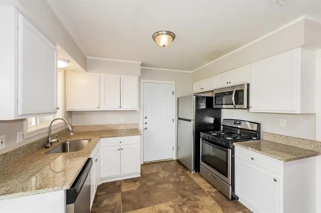 a kitchen with granite countertop a sink and a stove