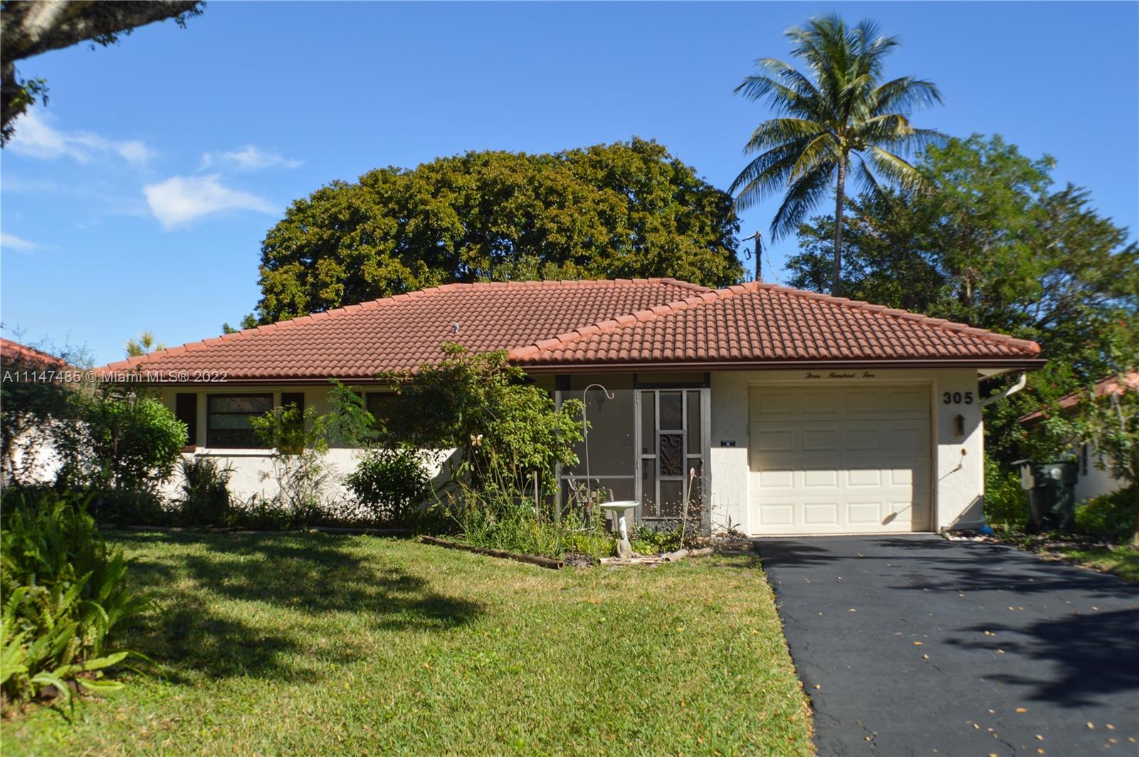 305 Northwest 42nd Street Boca Raton, FL 33431 - Photo 2 of 23 a front view of a house with garden