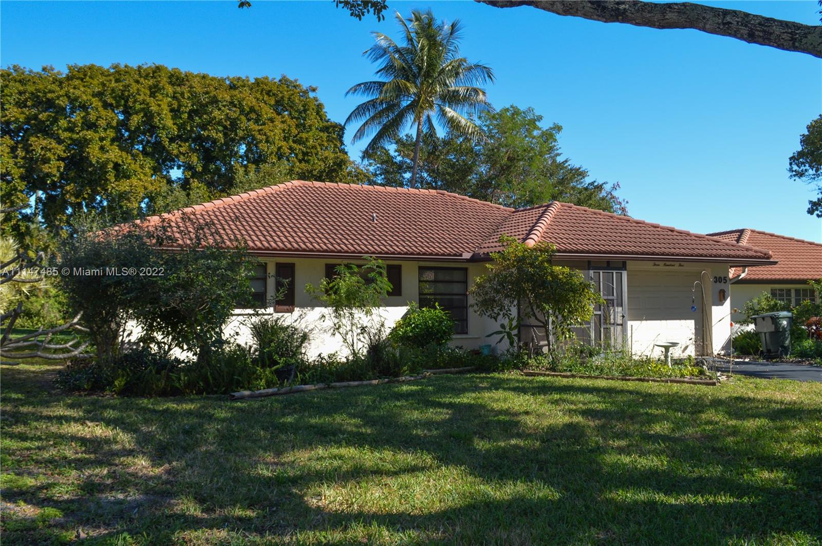 305 Northwest 42nd Street Boca Raton, FL 33431 - Photo 21 of 23 a front view of a house with a yard