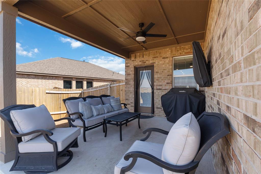 1012 Calhoun Drive Anna, TX 75409 - Photo 37 of 39 Covered patio featuring concrete flooring, a ceiling fan, a brick exterior wall, and a wooden privacy fence