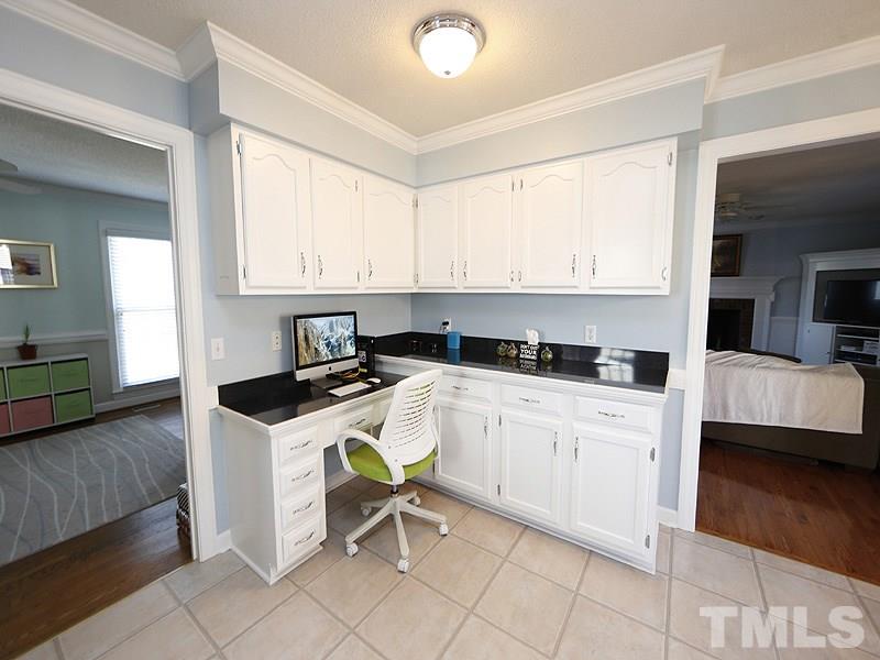 8512 Council Court Raleigh, NC 27615 - Photo 8 of 24 a kitchen with a stove a sink a counter top space and cabinets
