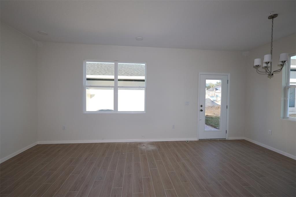 659 Pothos Street Apopka, FL 32703 - Photo 14 of 34 an empty room with wooden floor and windows