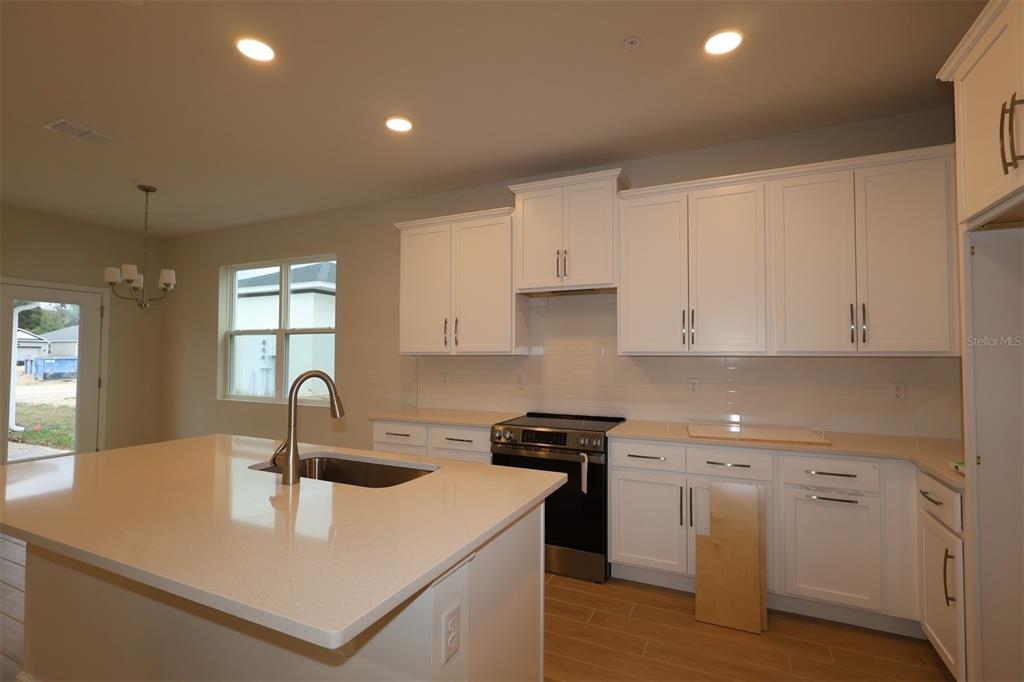 659 Pothos Street Apopka, FL 32703 - Photo 18 of 34 a kitchen with a sink a stove and cabinets