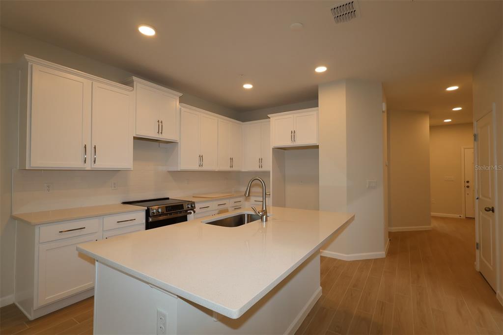 659 Pothos Street Apopka, FL 32703 - Photo 3 of 34 a kitchen that has a sink a stove and a refrigerator