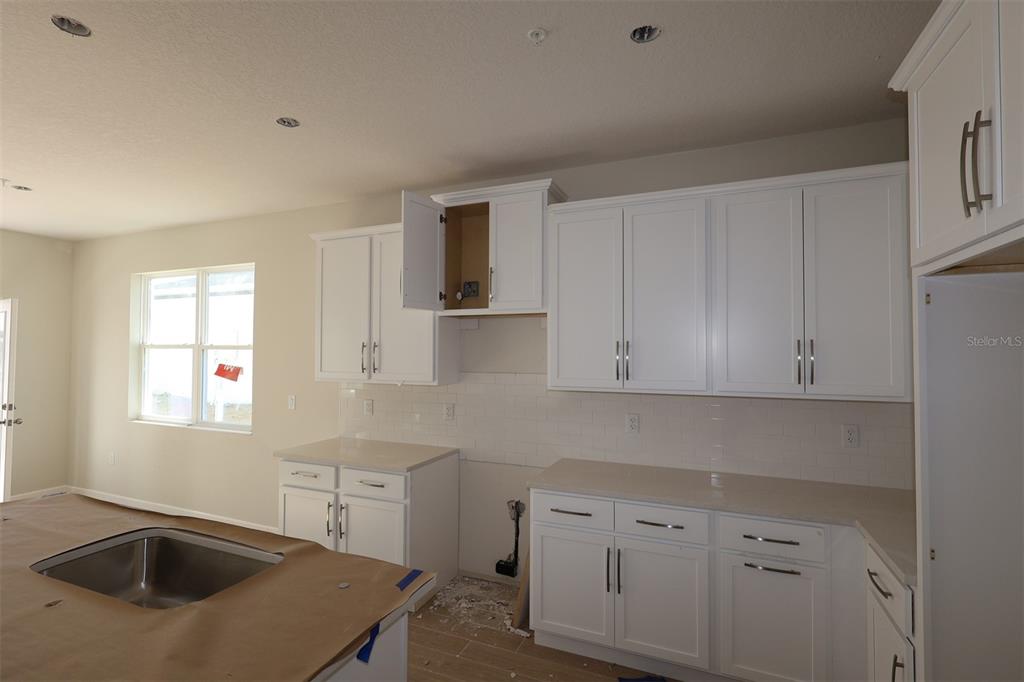 659 Pothos Street Apopka, FL 32703 - Photo 5 of 34 a kitchen with a sink stove and cabinets