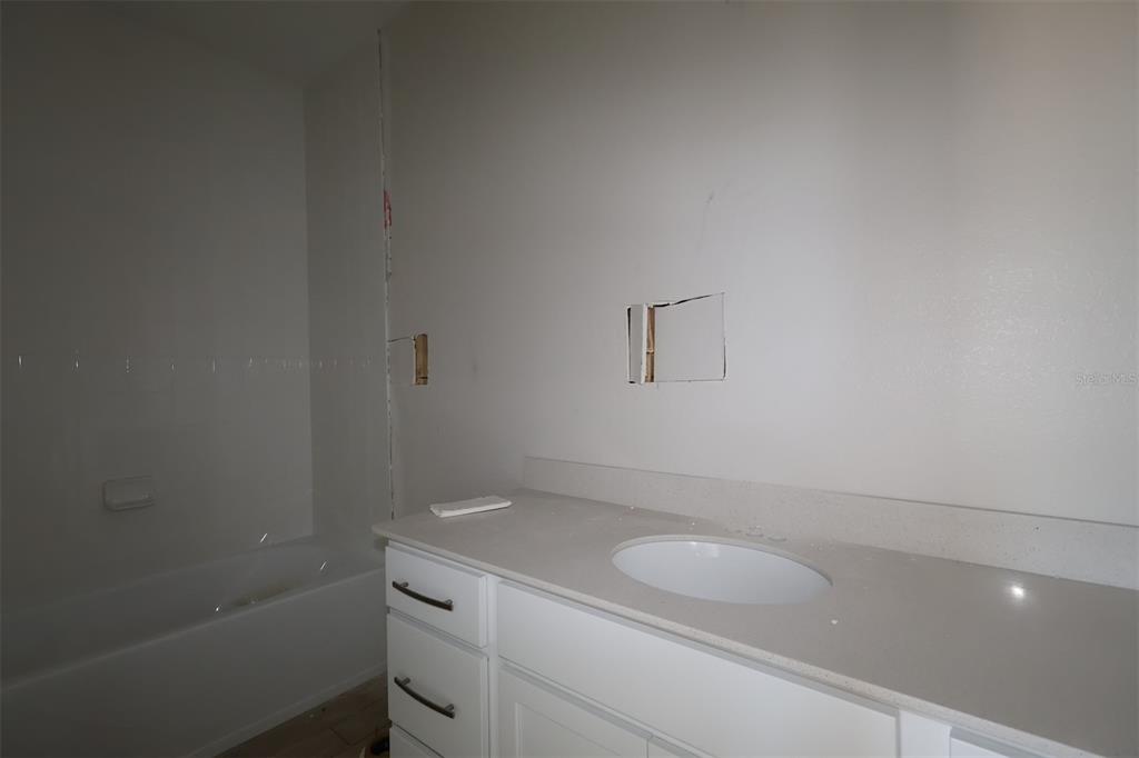 659 Pothos Street Apopka, FL 32703 - Photo 7 of 34 a bathroom with a granite countertop sink a toilet and bathtub