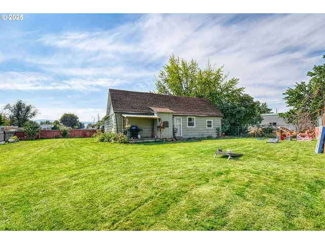 a front view of house with yard and trees in the background