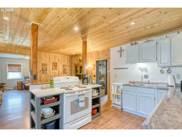 a large kitchen with stainless steel appliances kitchen island granite countertop a sink stove and refrigerator
