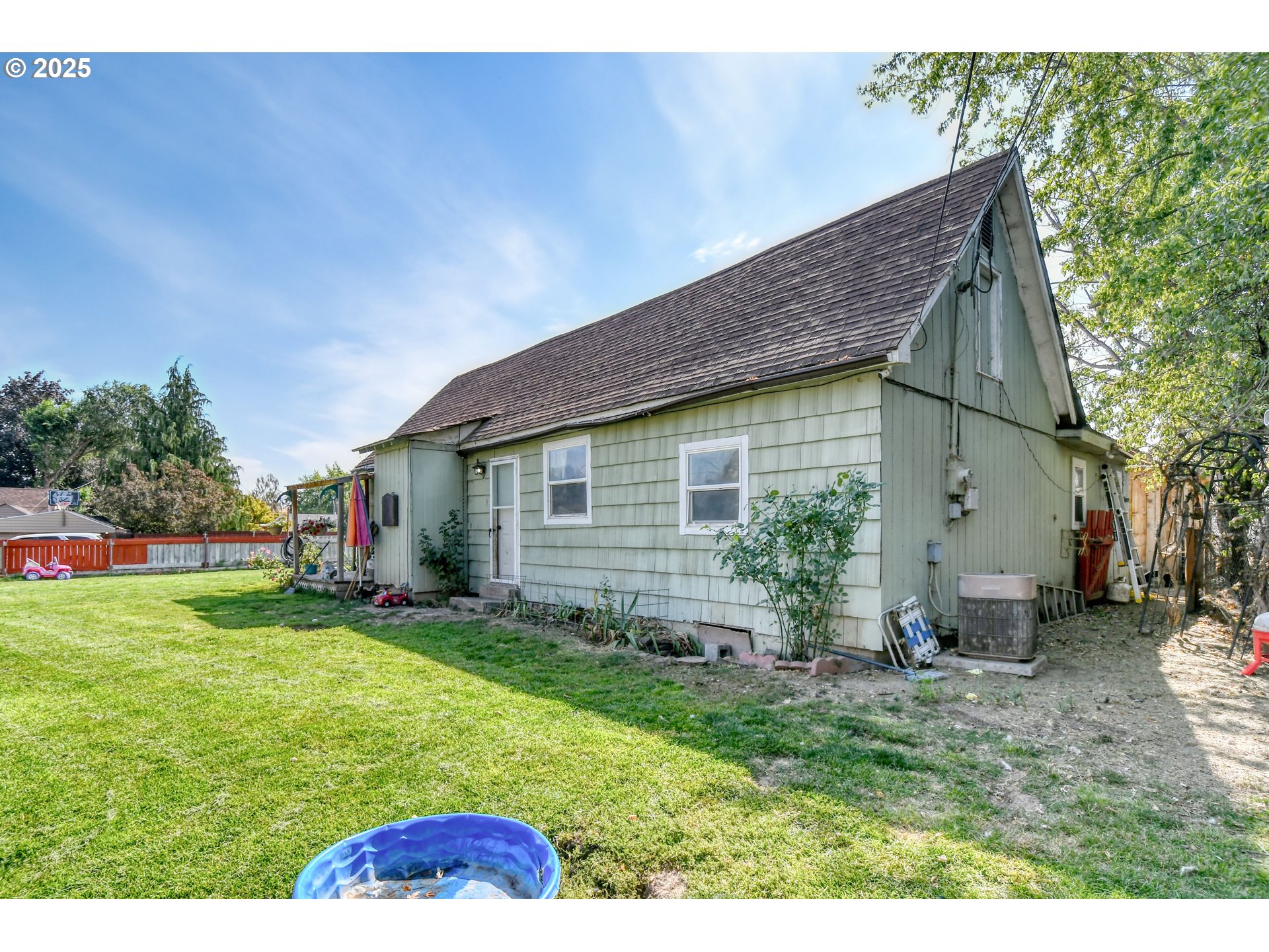 559 Southwest Cedar Street Pilot Rock, OR 97868 - Photo 2 of 42 a backyard of a house with potted plants and large tree