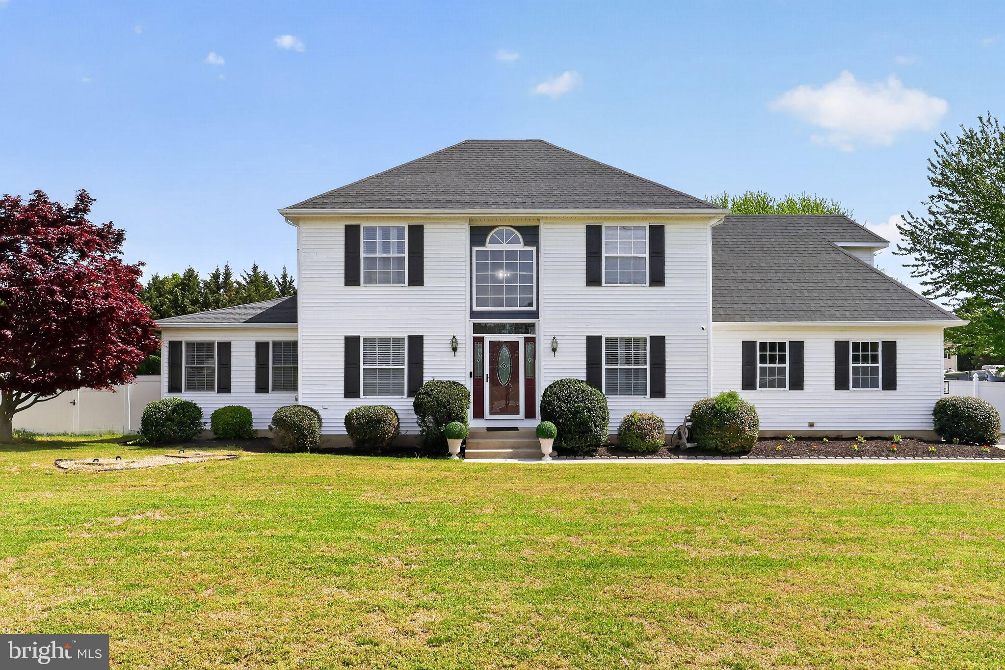 Charming two-story home with lush greenery.