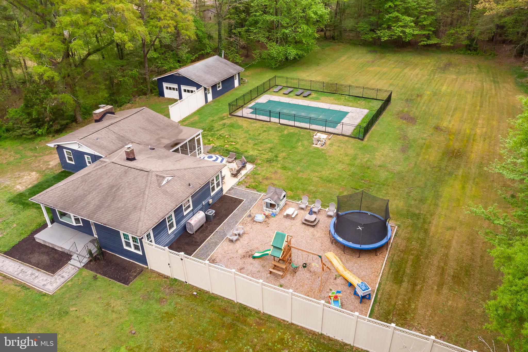 an aerial view of a house with swimming pool and big yard