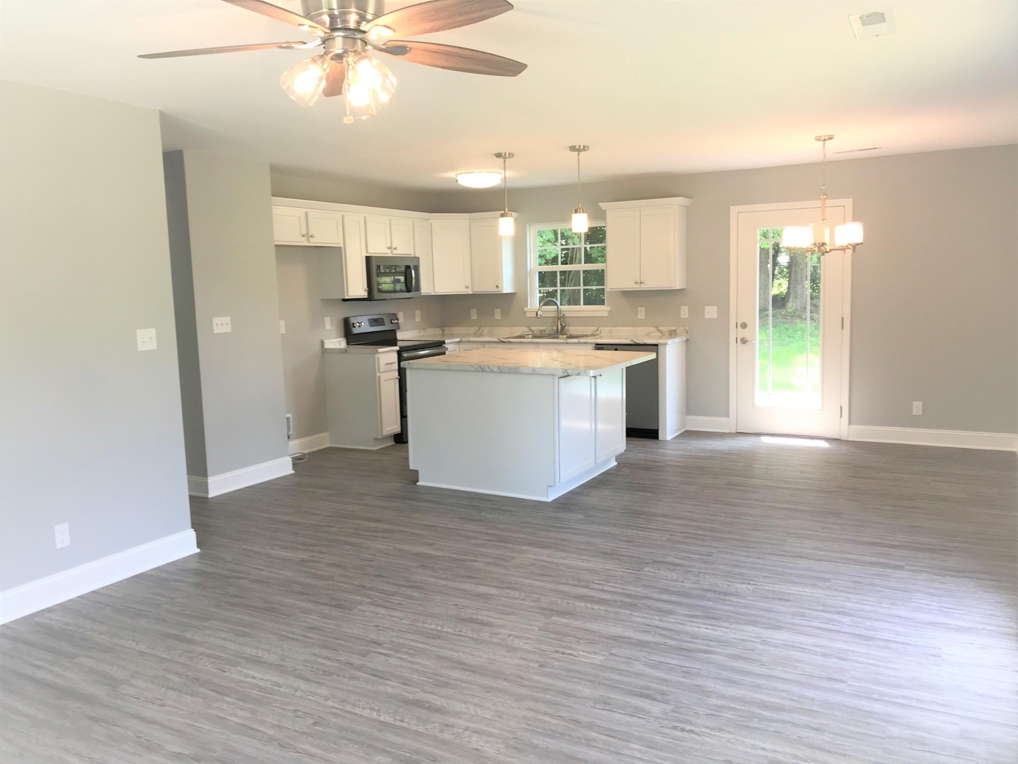 127 West Lincoln Road Oak Ridge, TN 37830 - Photo 4 of 32 a large kitchen with cabinets wooden floor and stainless steel appliances