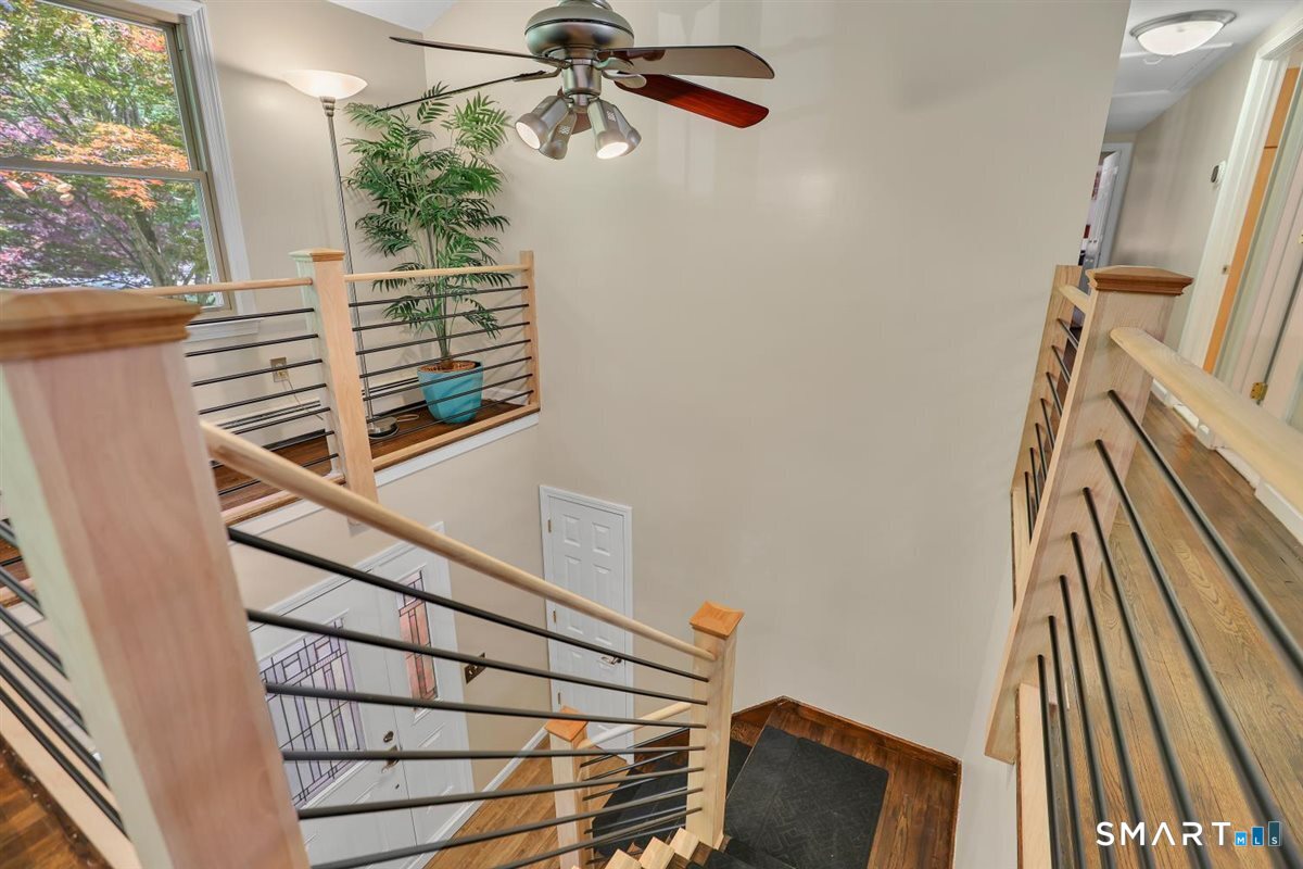 122 Ridgeview Circle Guilford, CT 06437 - Photo 4 of 40 Updated staircase off the foyer with natural wood tones and metal accents provides a striking architectural feature and welcomes you to both the first and second levels.