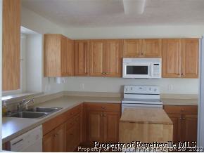 122 Chesapeake Road Cameron, NC 28326 - Photo 9 of 10 a kitchen with stainless steel appliances granite countertop a sink stove and cabinets
