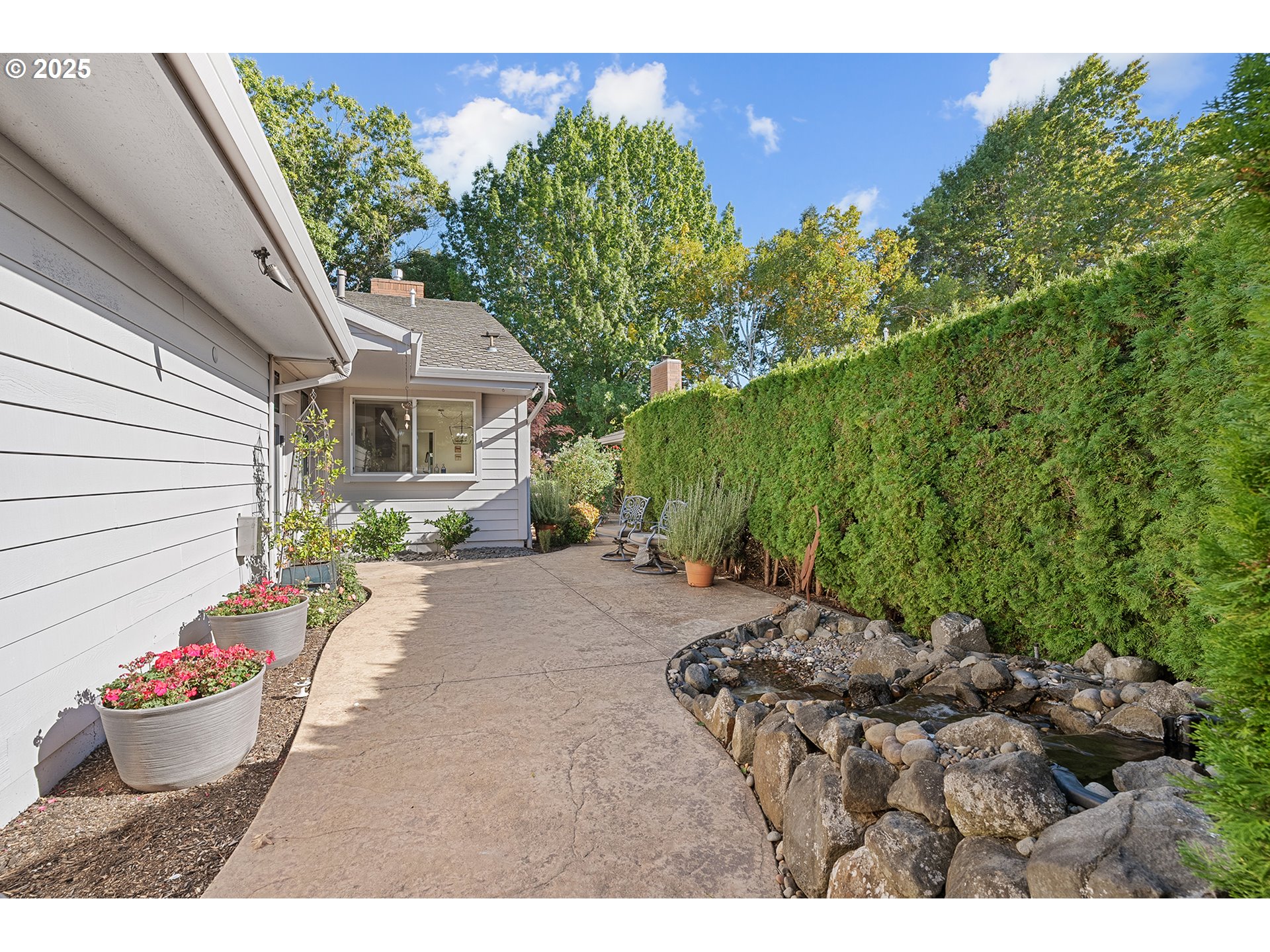 32215 Southwest East Lake Point Wilsonville, OR 97070 - Photo 4 of 47 a view of a backyard with table and chairs potted plants and large tree