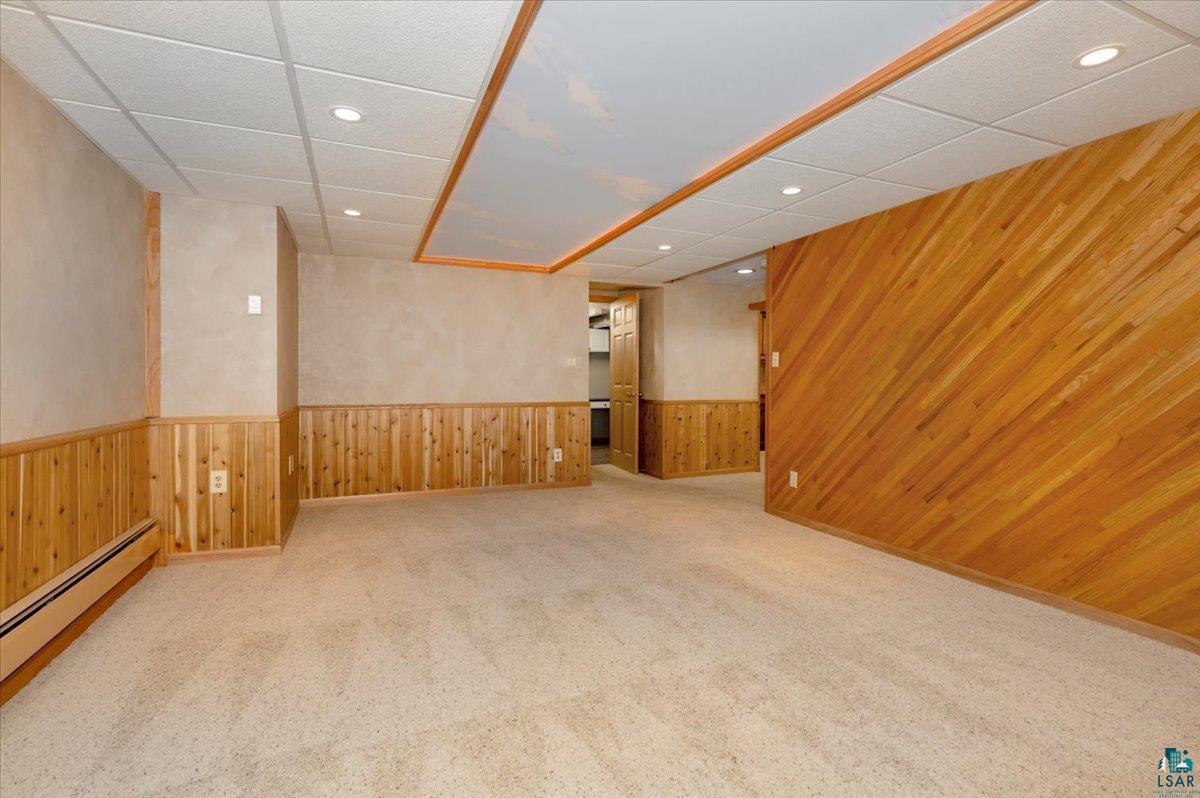 5219 West Arrowhead Road Hermantown, MN 55811 - Photo 21 of 35 Basement featuring a baseboard heating unit, carpet flooring, and a paneled ceiling