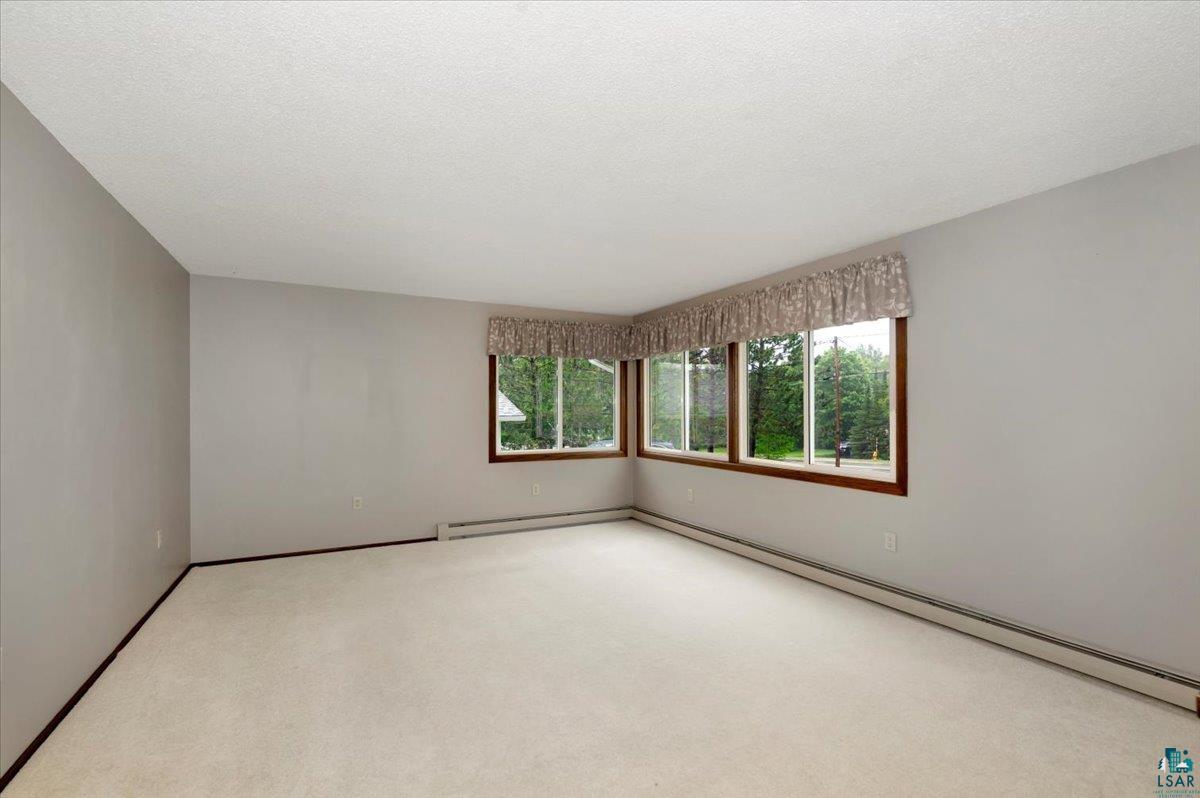 5219 West Arrowhead Road Hermantown, MN 55811 - Photo 3 of 35 Carpeted empty room with a baseboard heating unit