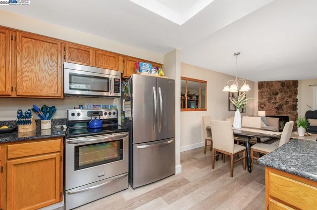 a kitchen with granite countertop stainless steel appliances and wooden cabinets