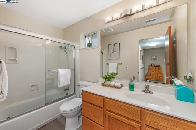 a bathroom with a granite countertop sink toilet and shower