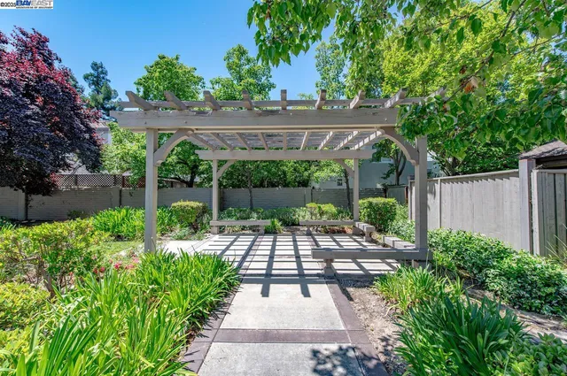 a view of a patio with furniture and a garden