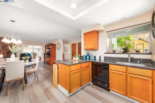 a kitchen with stainless steel appliances granite countertop sink stove top oven and cabinets