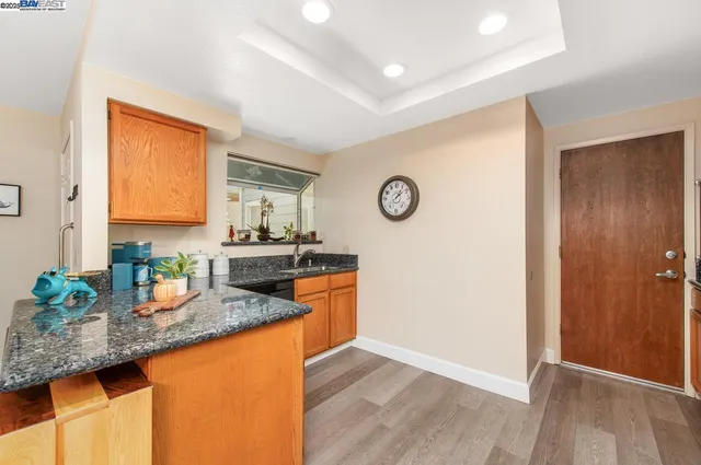 a kitchen with granite countertop stainless steel appliances a sink a counter top space and cabinets