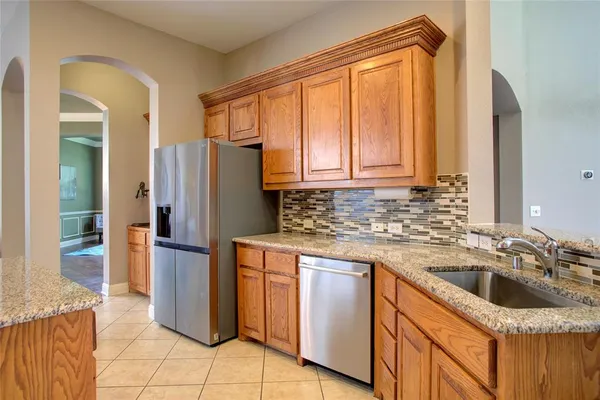 a kitchen with granite countertop a refrigerator and a sink