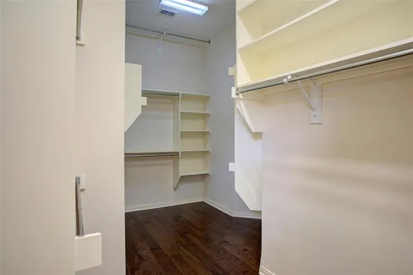 a view of walk in closet with empty racks