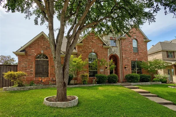 a front view of a house with a yard and fountain