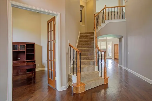 a view of a hallway with wooden floor and staircase