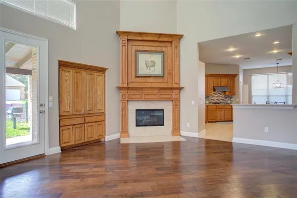 a view of a livingroom with a fireplace wooden cabinet and windows