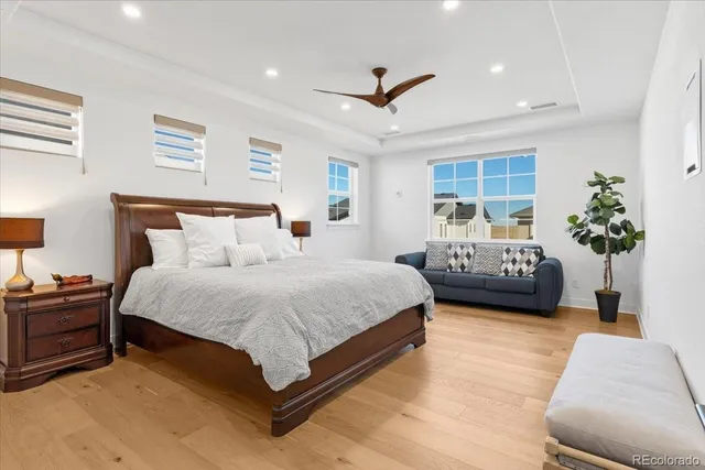 a spacious bedroom with a bed chandelier and a window