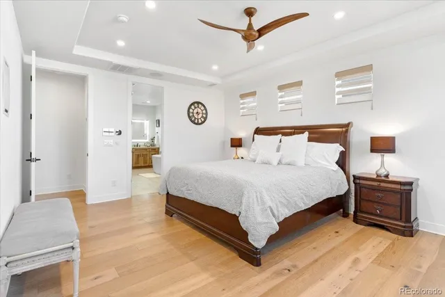 a spacious bedroom with a bed and a lamp on a table