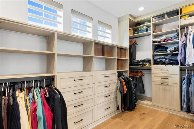 a view of walk in closet with clothes and shoes