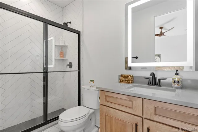 a bathroom with a granite countertop sink toilet and shower