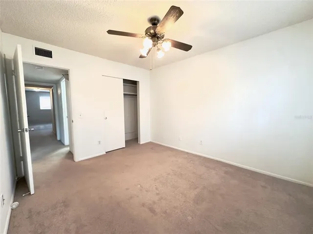 an empty room with a ceiling fan and a window
