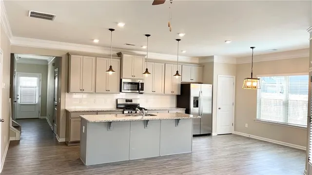 a kitchen with stainless steel appliances kitchen island refrigerator sink and cabinets