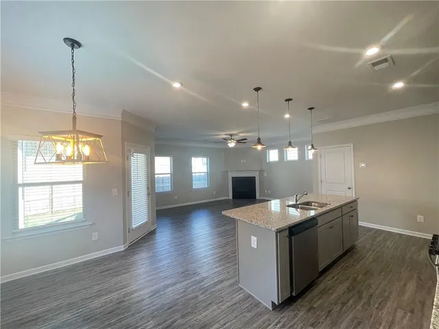 a kitchen with stainless steel appliances granite countertop a sink a stove and wooden floor