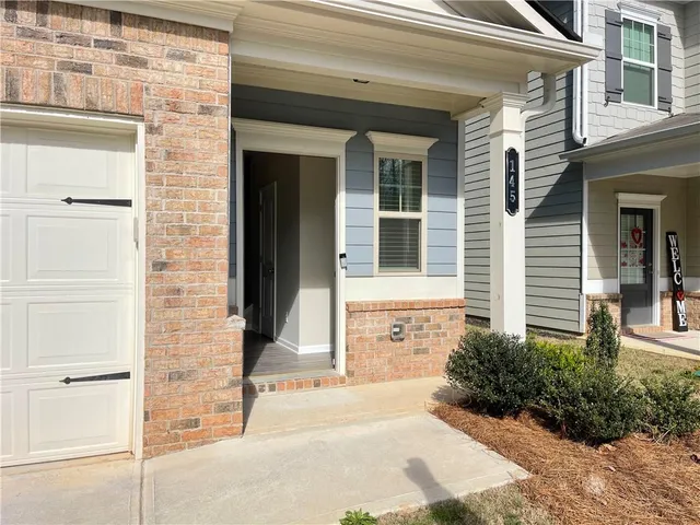 front view of a brick house with a small yard