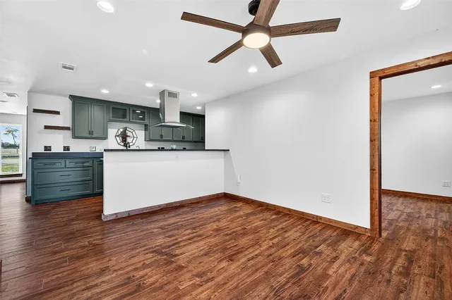 a kitchen with stainless steel appliances kitchen island wooden floors and view living room