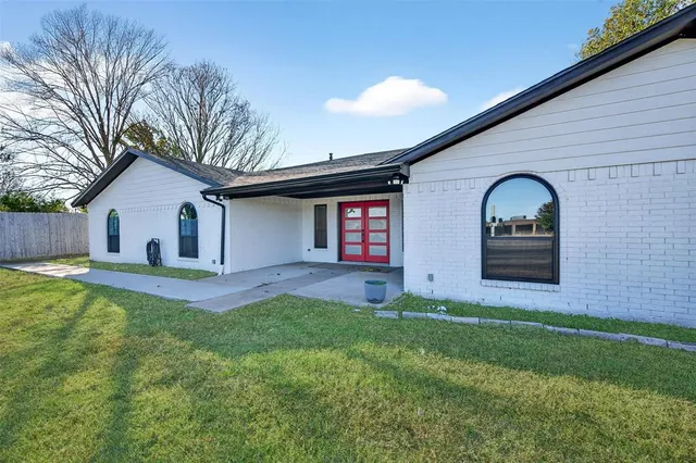 a view of a house with a yard and a large tree