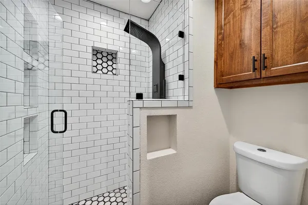 a bathroom with a toilet and a shower