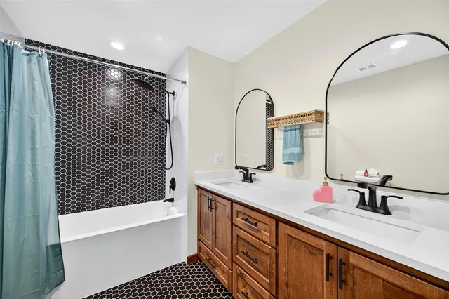 a bathroom with a double vanity sink and a mirror