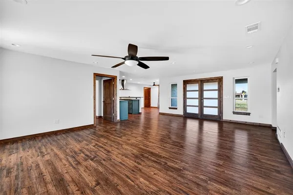 a view of empty room with wooden floor and window