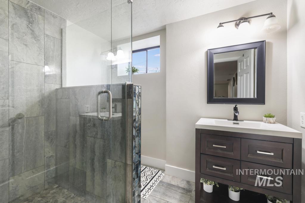 2243 4000 North Filer, ID 83328 - Photo 15 of 30 Full bath with vanity, a shower stall, and a textured ceiling