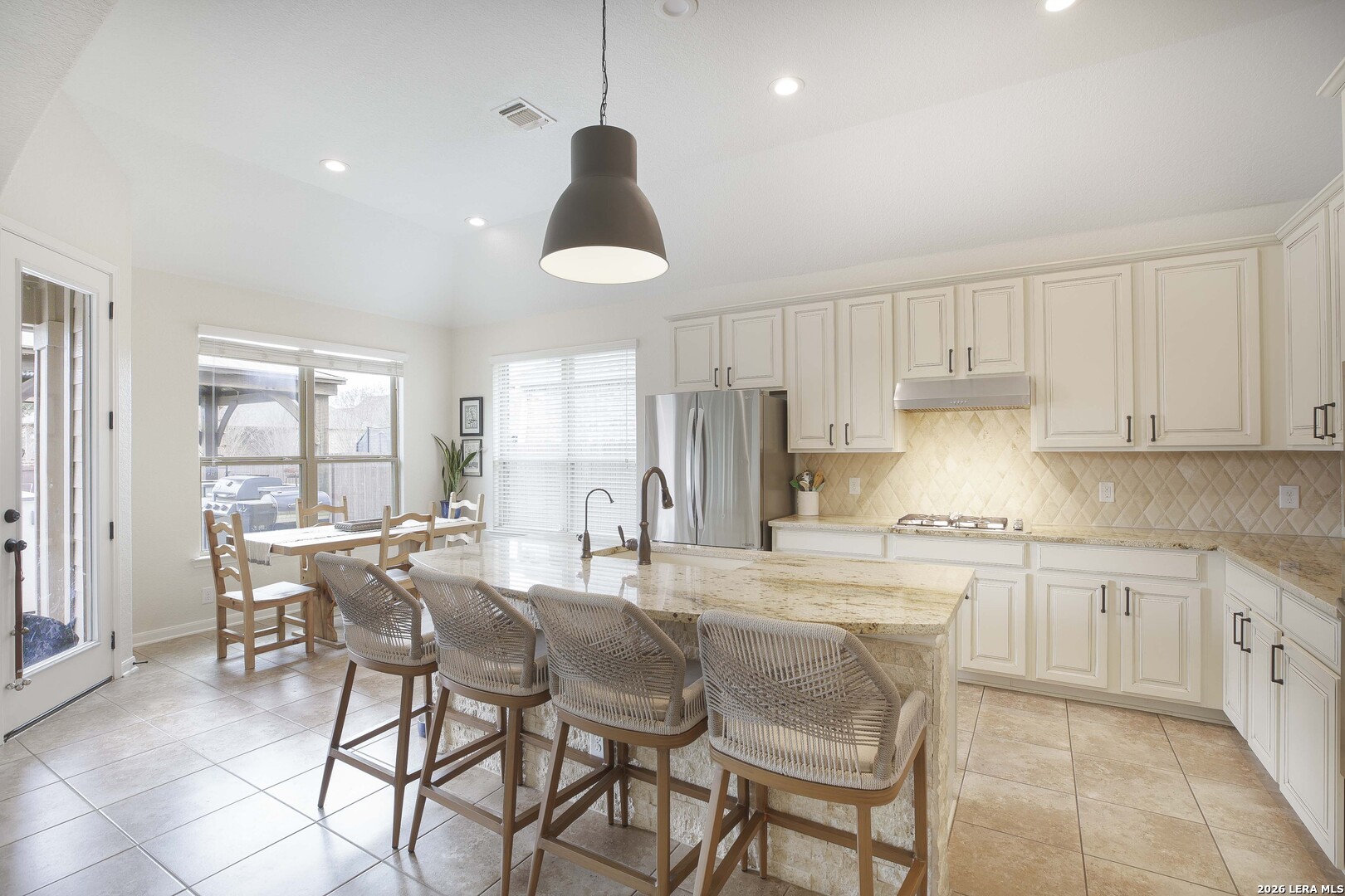 3806 Brahman Road Bulverde, TX 78163 - Photo 15 of 36 a kitchen with stainless steel appliances granite countertop a sink a stove a refrigerator and chairs